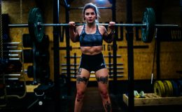 woman standing and carrying barbell