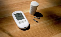 a thermometer, pills, and a bottle on a table